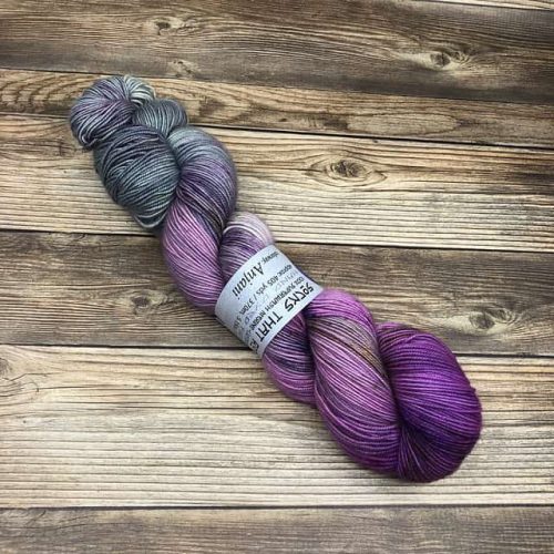 A skein of variegated yarn in purples and greys.